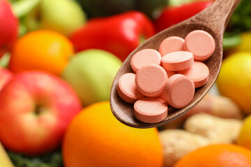 Dietary supplements in wooden spoon near products, closeup. Space for text