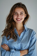 Obraz premium Portrait of a woman with long brown hair wearing a blue shirt. Suitable for various lifestyle and fashion concepts