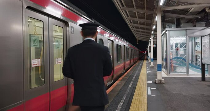 Train conductor man, walk and station for public transport services, commute or infrastructure on platform. Driver, locomotive and railway travel with person, back or suit for job by vehicle in Tokyo