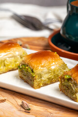 Turkish baklava. Mediterranean cuisine flavours. Pistachio baklava with turkish coffee on rustic table, ramadan or holiday desserts concept. Close up