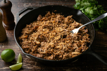 carnitas in skillet pan with tacos ingredients