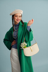 Fashionable happy smiling woman wearing beret, elegant green coat, turtleneck, layered pearl...