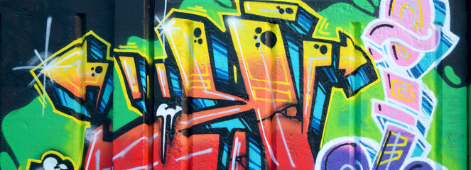 Naklejka premium Colorful background of graffiti painting artwork with bright aerosol outlines on wall. Old school street art piece made with aerosol spray paint cans. Contemporary youth culture backdrop