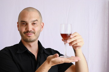 expressive bald man holding a glass of wine , funny wine advertising presentation