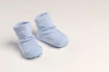 baby socks, for newborns, the first shoes with delicate feet on a light background