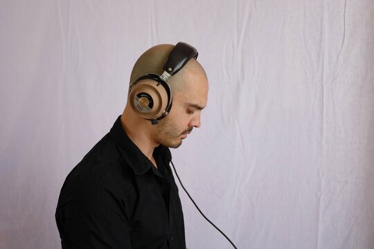 baldman wearing headphones , music listening and funny expressions