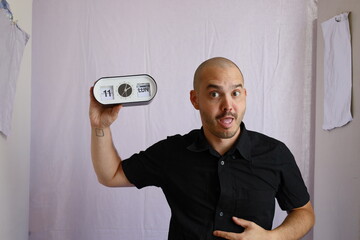 expressive bald man holding and showing the analog clock