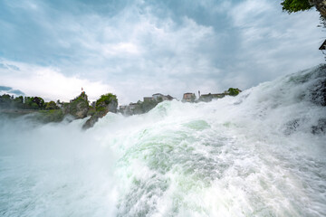 Huge water floods fall from the mighty Rhine Falls next to Laufen Castle. Rhine Falls, Neuhausen am Rheinfall, Schaffhausen, Switzerland.