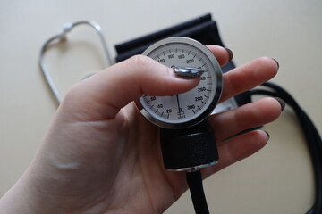 black manual heart pressure monitor on a beige background
