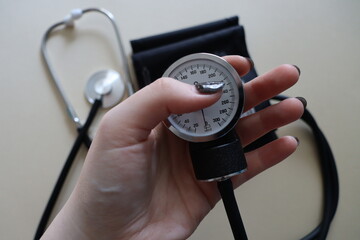 black manual heart pressure monitor on a beige background