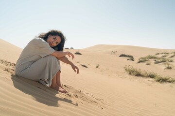 Arabic woman sitting on the sand in the desert