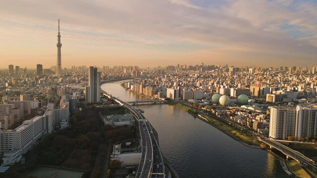 tokyo city skytree aerial view drone at sunrise,high shot of asakusa district flying over sumida river at dawn