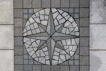 A grey and white mosaic tile floor with a star pattern - 751003385