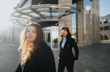 Young female entrepreneurs working outdoors in urban setting.