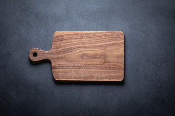 Handmade wooden cutting board background. A handcrafted black walnut wood chopping board sits on a...