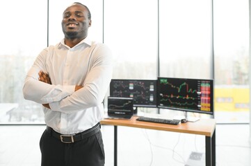 African-American broker works in office using workstation and analysis technology