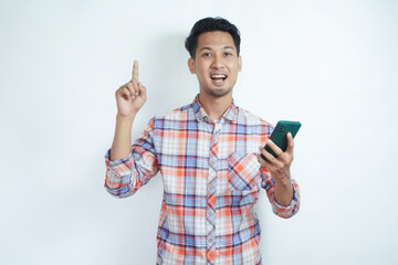 Adult man showing happy expression with finger pointing up when holding mobile phone