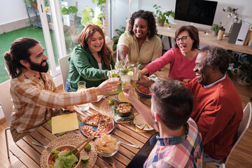 Group of friends toasting, overhead view at a special celebration dinner. Concept: together.