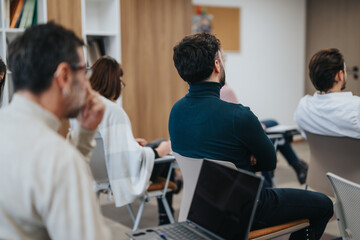 Focused male participant in professional workshop with laptop in modern office.