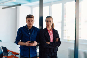 The director of an IT company poses with her colleague in a modern startup office setting