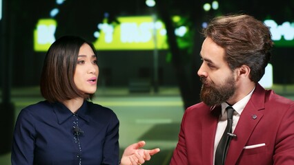 Reporters team on night talk show, presenting daily events and international issues on live program. Professional hosts doing newscast segment for entertainment, talking about latest media scandals.