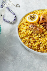Chicken Biryani with Spices and Lemon on White Plate, Concrete Background, Copy Space