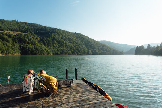 People enjoy the sun by the lake