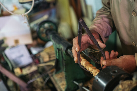 Artisan with instrument measuring wood detail