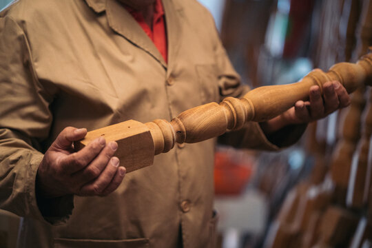 Carpenter with wooden balustrade in workshop