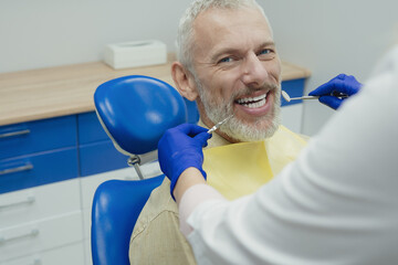 Dental doctor treating a male patient in hospital.