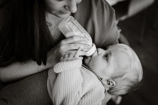 black and white image of Mother feeding milk in a bottle