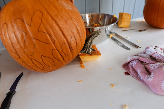 Oversized pumpkin with black shapes drawn on its surface. 