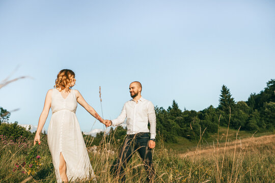 A down-looking photograph of a couple holding hands