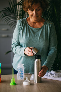 Senior grandmother preparing food for baby 