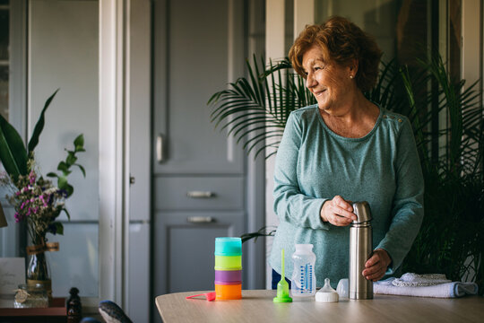 Senior grandmother preparing food for baby 