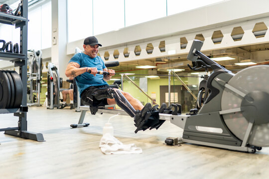 Sportsman with leg prosthesis training in gym