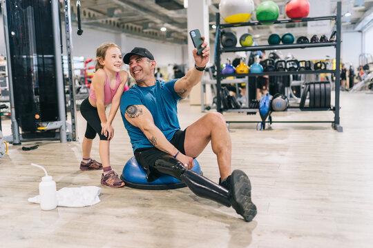 Fit man with bionic leg taking selfie with child