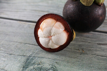 Mangosteen isolated on wooden background. Known as The Queen of Fruits, asia fruits concept. Sweet...