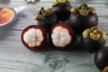 Mangosteen isolated on wooden background. Known as The Queen of Fruits, asia fruits concept. Sweet tropical fruit.