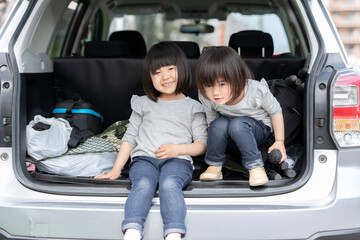 車の荷台に座っている女の子の姉妹