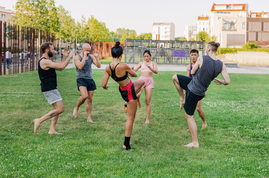 Muay Thai trainees high-kick in a circle