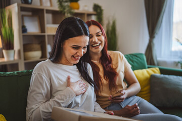 two women young teenage females at home open post package box
