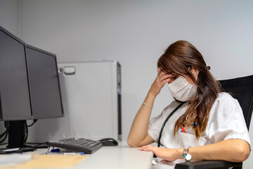 Tired doctor sitting at desk
