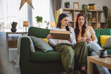 Obraz premium two women young teenage females at home open post package box
