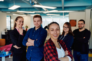 Portrait of a successful creative businessman and businesswoman looking at camera and smiling. Diverse business people standing together at startup.
