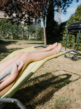 Legs in the long chair in garden