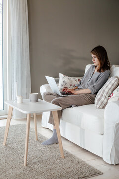 Female spending time on couch using laptop 