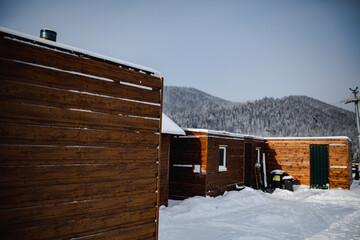 Camper vans and tiny houses near forest and ski lifts. 