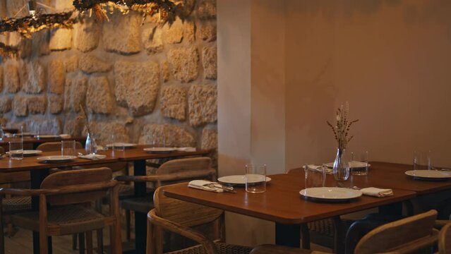 Cozy served restaurant tables under warm light original lamps. Cafe interior
