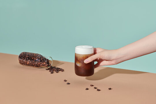 Coffee with air cream in a transparent glass on a color background